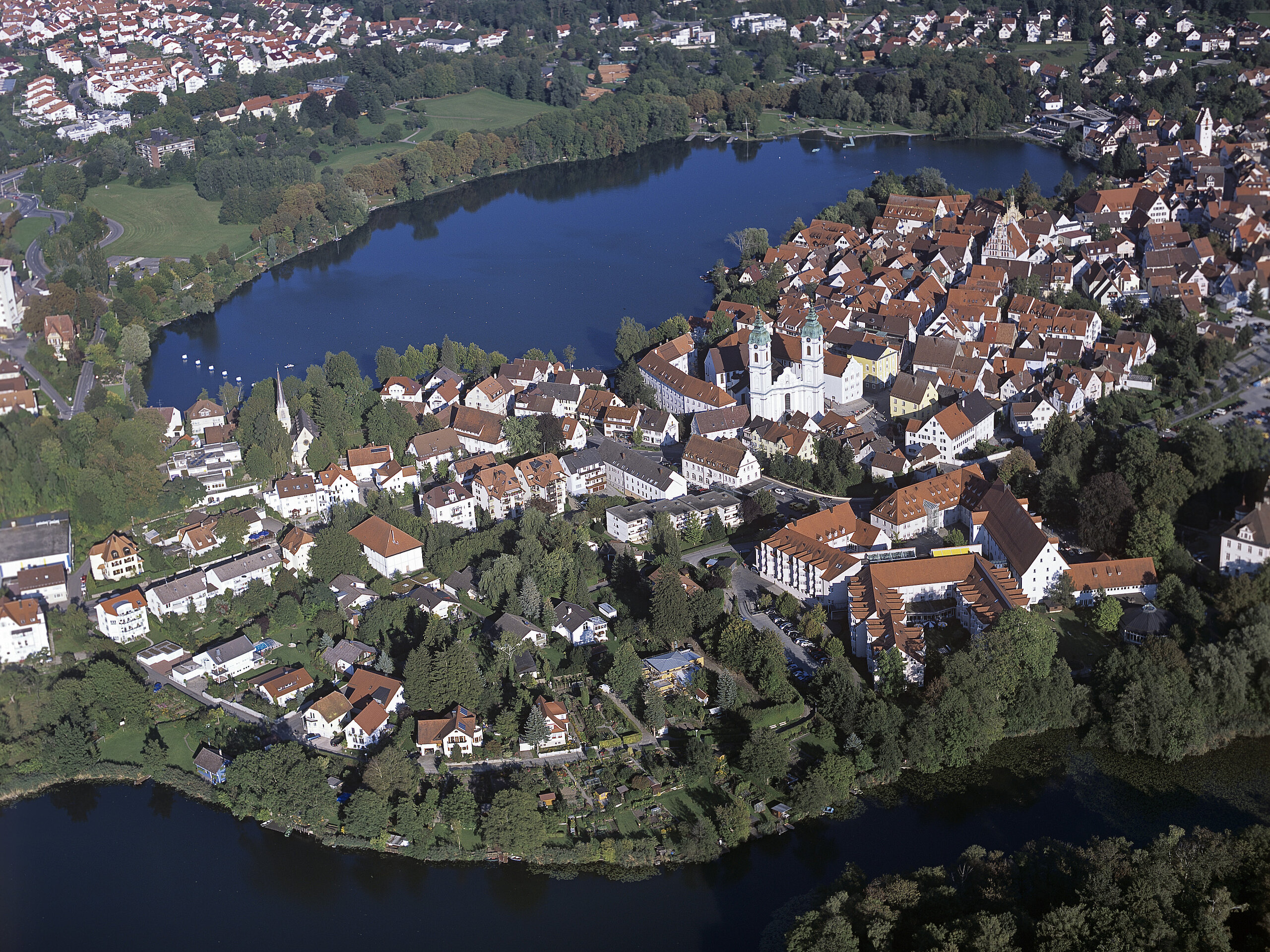 Luftaufnahme von Bad Waldsee mit Stadtsee, Altstadt und umliegender Landschaft.